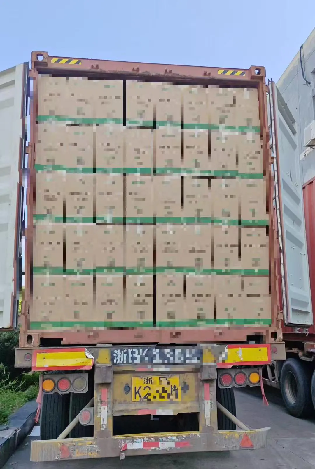 Mixed packaging cartons loaded for export with labels redacted